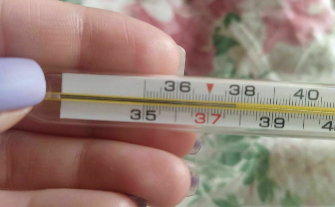 Ртутный термометр с температурой 39 в руках на белом фоне